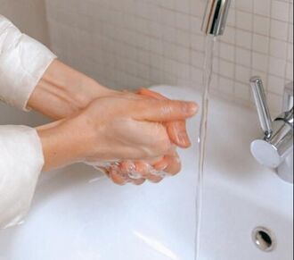 Person washing hands to prevent the spread of illness.